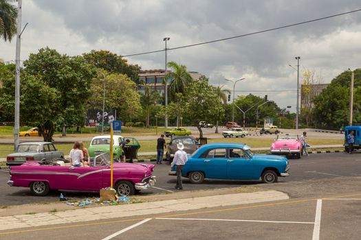 HAVANA, CUBA - CIRCA 2017: group of American green classic taxi cars waiting for tourists in Plaza de la Revolucion in Vedado Cuba