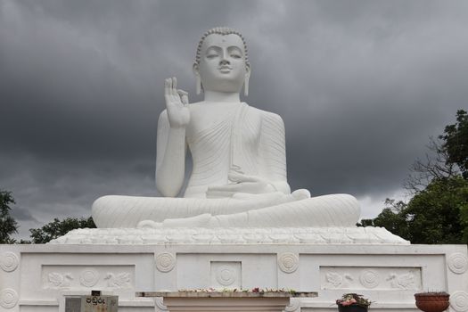 Mihintale, Sri Lanka - CIRCA 2018: Big white Buddha statue against blue sky in Mihintale, the cradle of buddhism at Sri Lanka