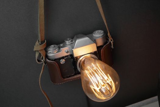 Retro lamp from an old camera with an Edison lamp on a gray background. Concept is a good idea. High quality photo