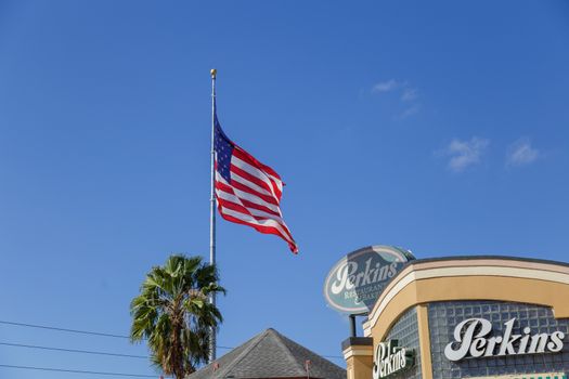 Orlando, Florida, USA - CIRCA, 2019: : Perkins Family Restaurant and Bakery Location with American flag flying over a bright blue sky