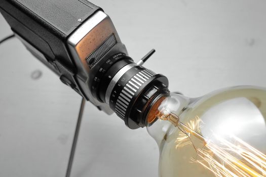 Retro lamp from an old camera with an Edison lamp on a gray background. Concept is a good idea. High quality photo