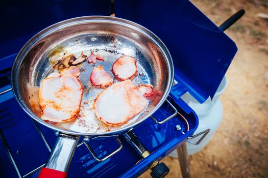 Cooking bacon on a camp oven in the Grampians, Victoria, Australia