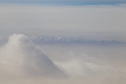 Aerial view of Himalaya mountains and clouds from an airplane. Concept of air travel.
