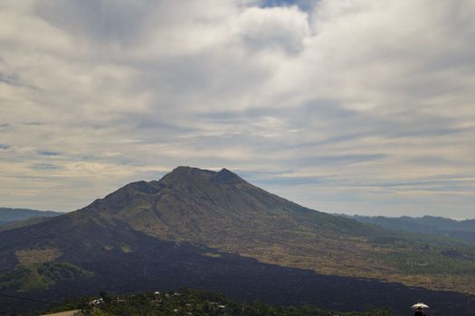 View of Indonesia Batur active vulcano with black lava all around.