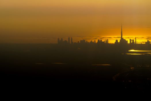 Low key contrasty beautiful aerial view of Dubai skyline with view over the Arabian Gulf during a sunset.