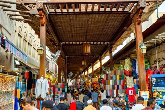Dubai, United Arab Emirates - CIRCA 2020: Shops and vendors in the ancient covered textile souq Bur Dubai in the old city center. Crowded souq market. Concept of crowded place