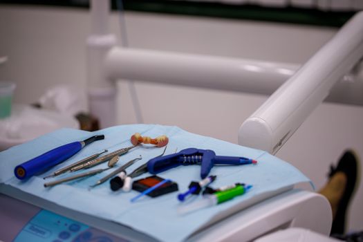 Set of Dentist 's medical equipment tools on tray ready for patient treatment. Patient dentures on a medical tray with stomatologist tools and utensils. Concept of oral and tooth care