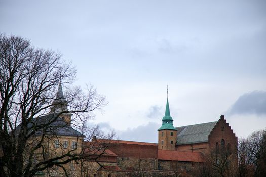 Akershus Fortress is a historical medieval castle structure in Oslo, Norway which has gardens, cannons, and beautiful views from the surrounding parapets. Moody cloudy weather with ominous clouds.
