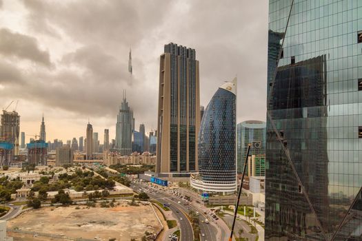 DUBAI, UNITED ARAB EMIRATES, CIRCA 2020: Burj Khalifa and Dubai skyline with dramatic cloudy sky in the background. Concept of hard stormy times