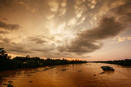 A stunning sunset with storm in the distance on the Mekong River near Can Tho in Vietnam