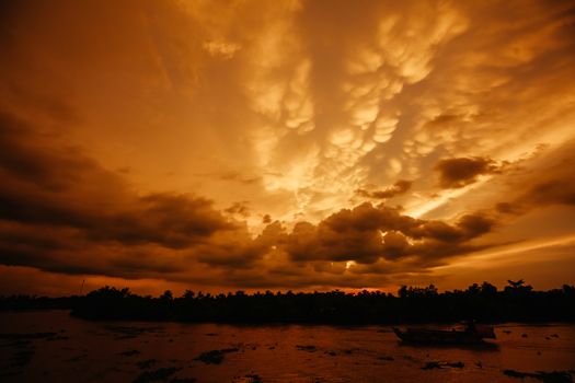 A stunning sunset with storm in the distance on the Mekong River near Can Tho in Vietnam