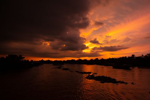 A stunning sunset with storm in the distance on the Mekong River near Can Tho in Vietnam