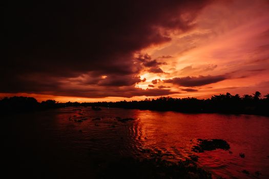 A stunning sunset with storm in the distance on the Mekong River near Can Tho in Vietnam