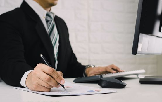 Business men work on the table Analyze graphs financial report in documents and computers.