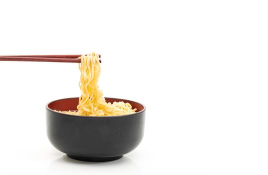 noodle chopsticks in a black bowl on a white background
