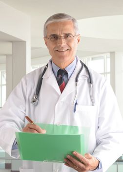 Middle aged doctor writing in chart in modern medical facility