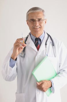 Middle Aged Doctor in Labcoat with Syringe and  Stethoscope and Chart vertical format