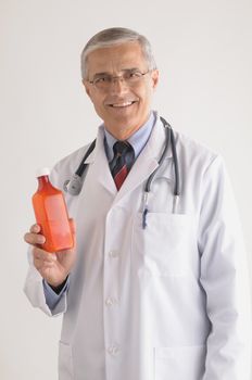 Smiling Middle Aged Doctor in Labcoat with Stethoscope and Medicine Bottle