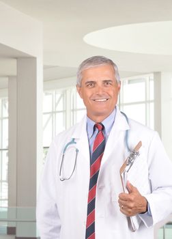 Middle Aged Doctor Holding Clipboard in Modern Medical Facility Setting vertical