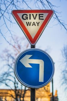 A give way sign and left turn road sign in England