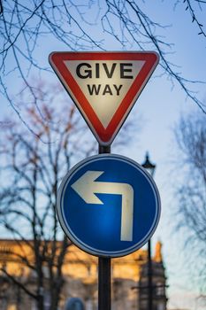 A give way sign and left turn road sign in England