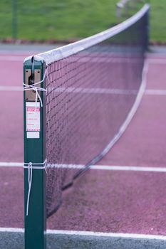 A close up of an outdoor tennis court net in the UK