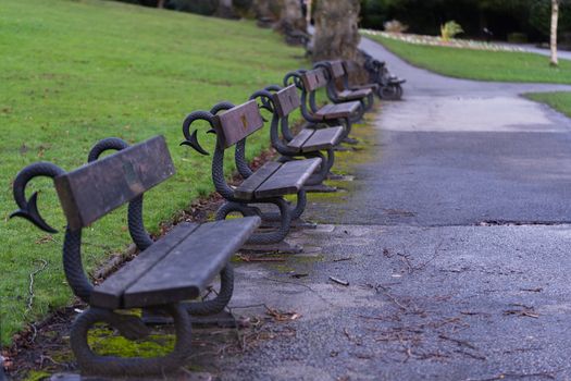 Traditional wooden park benches in a local park in England