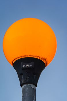 A close up of an orange illuminated zebra crossing light in England