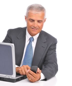 Businessman Dialing Cell Phone Seated at Computer isolated on white