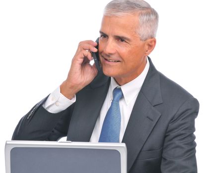 Businessman with Cell Phone Seated at Computer looking away from camera