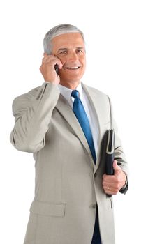 Middle aged businessman talking on his cell phone and carrying a binder. Man is smiling and looking at camera over a white background.