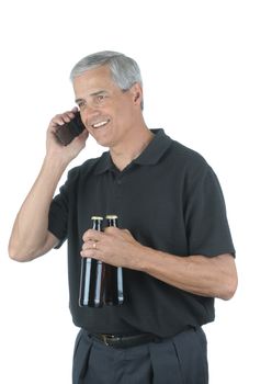 Middle Aged Businessman Talking on Cell Phone and holding two beers after a hard days work isolated over white