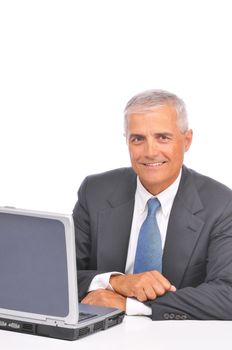 Mature Businessman smiling and looking over top of laptop isolated on white
