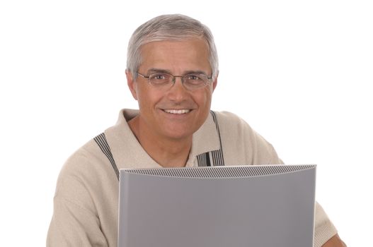 Middle aged businessman looking over the top of his computer monitor. Horizontal format with man smiling at the camera isolated on white.