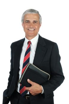 Portrait of a smiling middle aged business man holding a small binder with one hand in his pocket. Vertical format isolated on white.