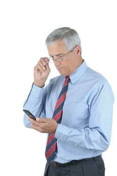 Middle Aged Businessman Looking at Cell Phone while adjusting his eye glasses isolated over white