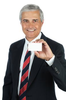 Portrait of a smiling middle aged business man holding a blank business card in front of his body. Vertical format isolated on white.