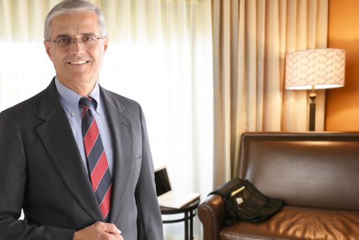 Portrait of a mature businessman in a hotel room. Business travel concept.