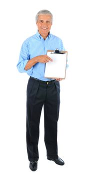 Smiling middle aged businessman standing pointing at a clipboard with a blank piece of paper. Full length over a white background.