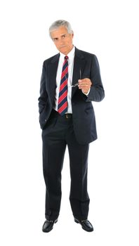 Serious middle aged businessman in a suit and tie standing with one hand in pocket and pointing with his glasses in opposite hand. Full length over a white background.