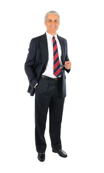 Smiling middle aged businessman wearing a suit standing with one hand in his pocket and the other holding his eye glasses. Full length over a white background.