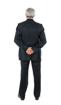 Standing middle aged businessman with both hands behind his back. Full length shot of the mans back over a white background.