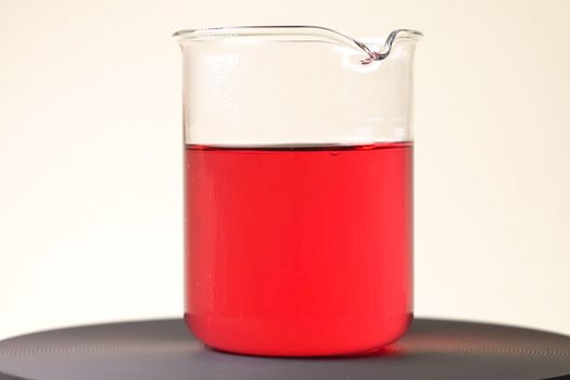 Red liquid in a glass glass. Chemical experiments