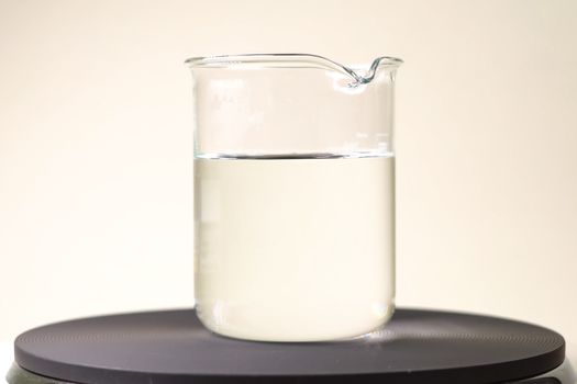 A glass with a clear liquid. Chemical experiments in the laboratory.