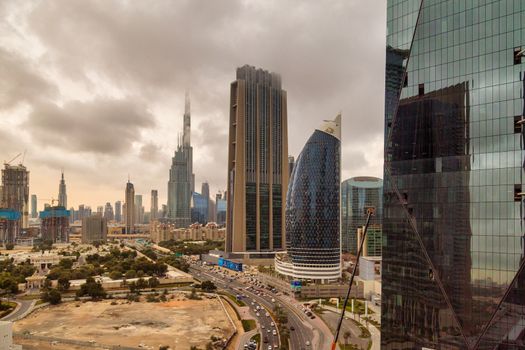 DUBAI, UNITED ARAB EMIRATES, CIRCA 2020: Burj Khalifa and Dubai skyline with dramatic cloudy sky in the background. Concept of hard stormy times
