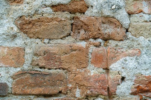 Grungy old red brick wall texture background with deterioration from age