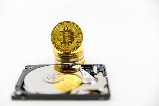 Stack of Gold bitcoin tokens on top of an open hard drive.Worldwide virtual internet cryptocurrency,digital payment system.Concept Digital coin money crypto currency on bitcoin farm.Copy space