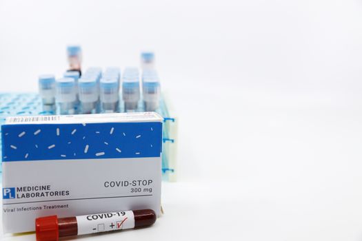 Coronavirus positive test in front of medicine.Concept of covid stop medicine with blood tests tubes on the background.Cure for coronavirus,COVID-19 treatment.