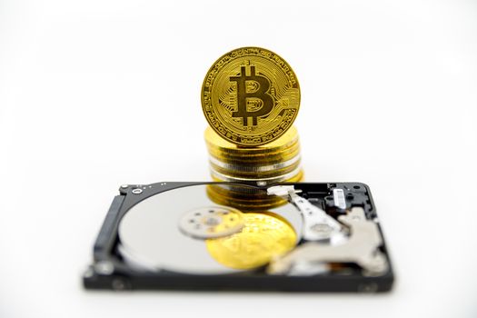 Stack of Gold bitcoin tokens on top of an open hard drive.Worldwide virtual internet cryptocurrency,digital payment system.Concept Digital coin money crypto currency on bitcoin farm.Copy space