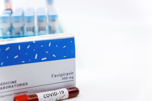Dubai-UAE-Circa 2020:Coronavirus positive test in front of medicine.Concept of Favipiravir medicine with blood tests tubes on the background.Cure for coronavirus,COVID-19 treatment.